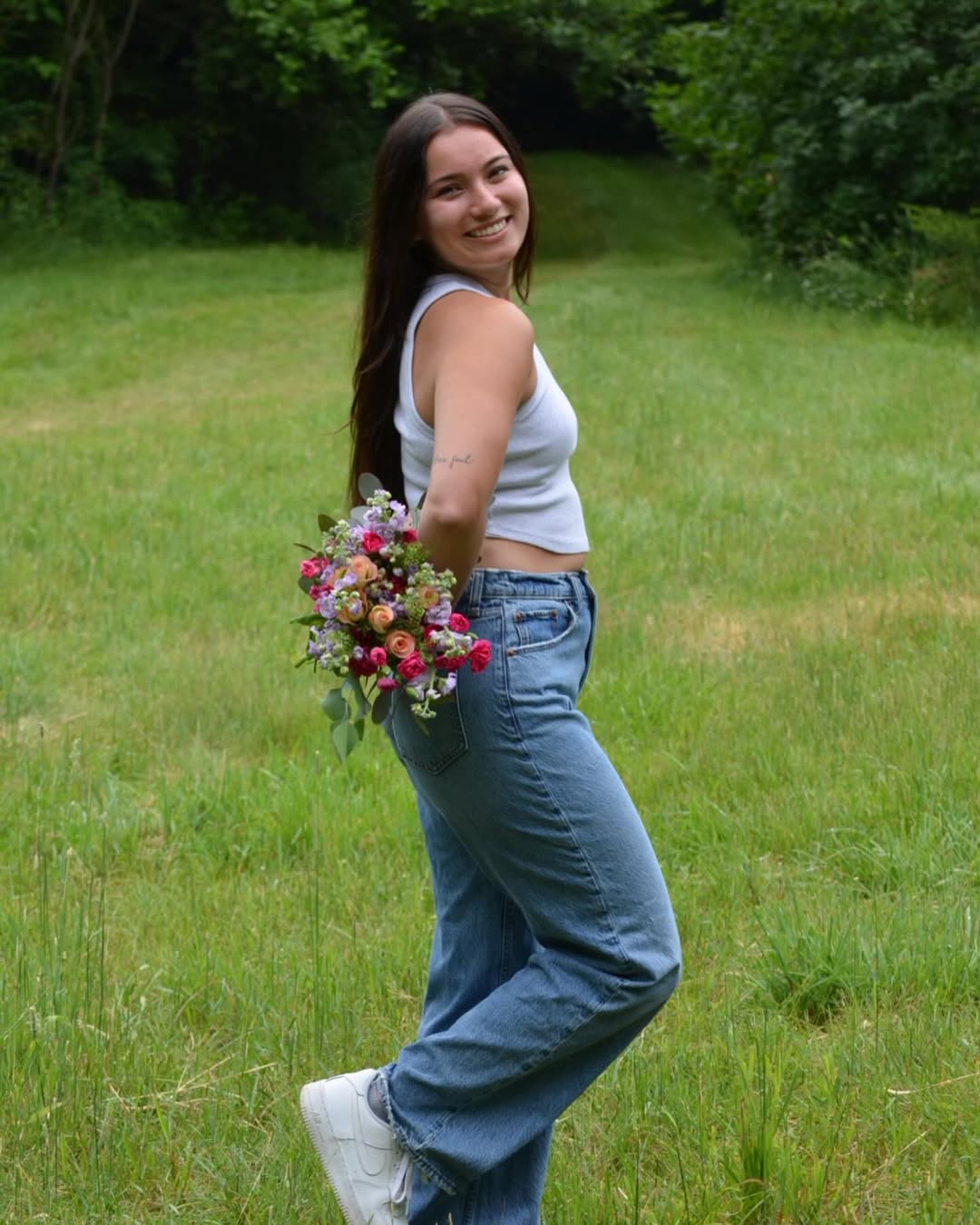 Haley with flower arrangement in a field